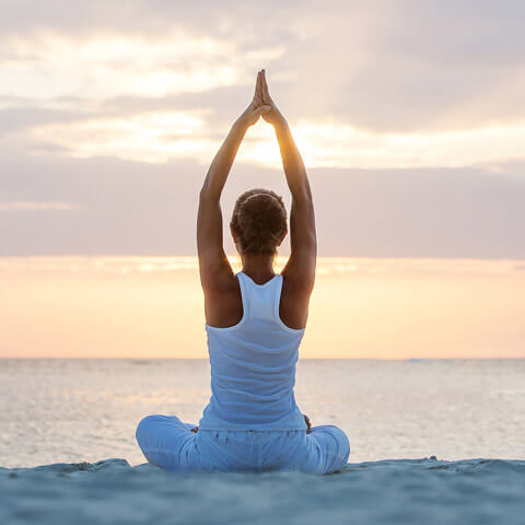 woman doing yoga on the beach