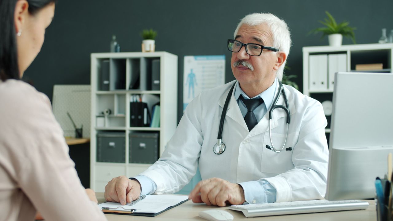 A doctor sitting at desk with patient